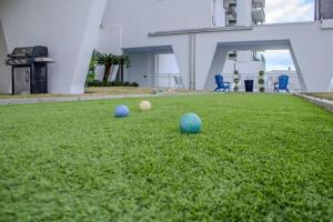 three balls sitting on the grass in a yard at Islander East Condominiums in Galveston +9 photos