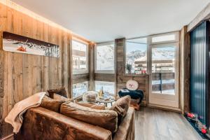 a living room with a couch and a table at Résidence Roches Rouges A - Pied de pistes, appartement chaleureux et douillet MAE-3523 in Tignes