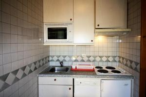 a kitchen with a sink and a microwave at Résidence Roches Rouges C - studio confortable, pied des pistes MAE-3580 in Tignes