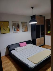 a bedroom with a large bed with a pink pillow at Nena Apartment in Kumanovo