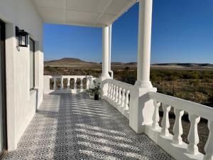 Un balcón blanco con vista al desierto. en Dellville Country House & Cottages, en Carnarvon