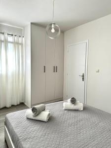 a white bedroom with two towels on a bed at Athena Apartment in Argostoli