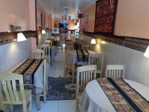 um restaurante com mesas e cadeiras num quarto em Hostal "Oro Blanco" em Uyuni