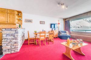 - un salon avec une table et une cheminée en pierre dans l'établissement Résidence Ducs De Savoie - Appartement 3, proche des pistes,commerce, vue lac MAE-3644, à Tignes