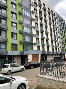 a large building with cars parked in front of it at 30# Galileo Terrace in Almaty