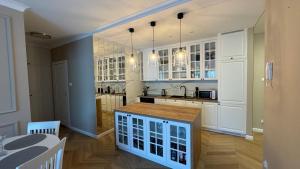 a kitchen with white cabinets and a table in it at Nowoczesny Apartament Tatarska in Przemyśl