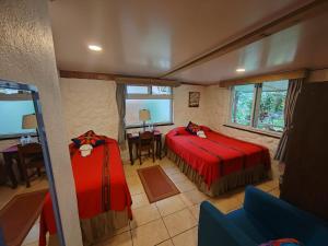 a bedroom with two beds and a table and chairs at Hotel Utz Jay in Panajachel