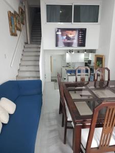 ein Esszimmer mit einem Tisch und einem blauen Sofa in der Unterkunft Tucacas Penthouse w Generator and Water Tank in Tucacas