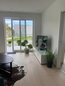a living room with potted plants and a large window at Møblert ferieleilighet i det fineste stedet i byen in Kristiansand