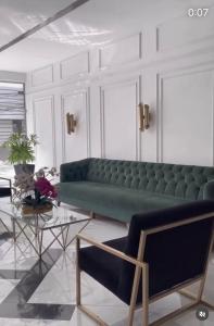 uma sala de estar com um sofá verde e uma mesa em Hotel OR Suite em Barranquilla
