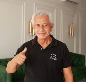 um homem mais velho está dando um sinal de positivo em Hotel OR Suite em Barranquilla