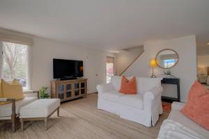 a living room with two white couches and a tv at Waterfront Private Dock Peaceful Retreat in Dennis