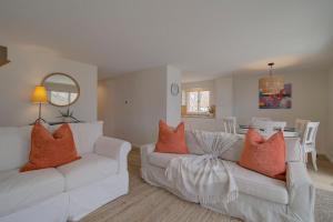a living room with two white couches with orange pillows at Waterfront Private Dock Peaceful Retreat in Dennis +34 photos