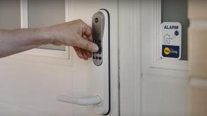 a person holding a remote control in front of a door at Near commuter train to Stockholm in Södertälje