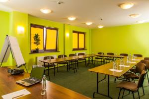 a conference room with tables and chairs and a laptop at Hotel Anek in Mrągowo