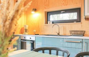 a kitchen with a sink and a table with chairs at Gorgeous Home In Nowe Warpno With Wifi in Nowe Warpno