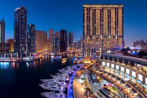 um horizonte da cidade à noite com barcos na água em JW Marriott Hotel Marina no Dubai