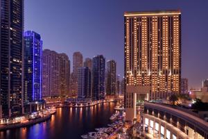 uma cidade à noite com um rio e edifícios altos em JW Marriott Hotel Marina no Dubai