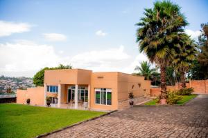 a house with a palm tree in front of it at Fleur Guest House in Kigali