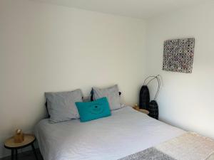 een slaapkamer met een bed met een blauw kussen erop bij Mer et fougères in Locmaria +21 foto's