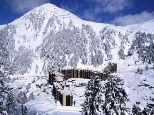 a snow covered mountain with a resort in the foreground at Résidence Carroley B - Appartement fonctionnel · Proche des pistes · Vue pistes MAE-4104 in Mâcot La Plagne +8 photos