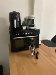 a black stove with a coffee maker on top of it at Studio lumineux - Départs de randonnées in Laruns