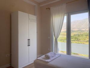 a bedroom with a white cabinet and a large window at Vila Bakalli in Vlorë