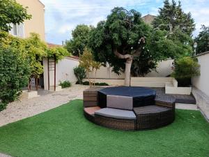 Maison Magnolia في Marcorignan: حديقة فيها كرسي وشجرة