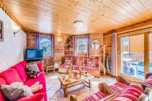 sala de estar con muebles de color rojo y TV de pantalla plana en Chalet Gypaete - Chalet Traditionnel 180m2 - 6 chambres, 6 salles de bain, jacuzzi MAE-5886, en Tignes