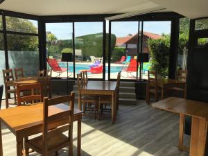 a restaurant with tables and chairs and a pool at Brit Hotel Dak Hotel in Avallon