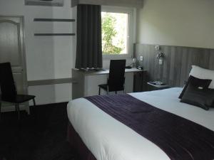 a hotel room with a bed and a desk at Brit Hotel Dak Hotel in Avallon