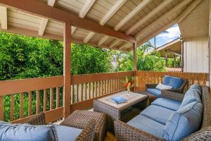 a covered porch with wicker chairs and a table at Contemporary 2-BR Condo AC & Scenic Views in PV in Princeville