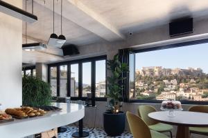 a kitchen with a table and chairs and a large window at Downtown Suites by Athens Tower in Athens