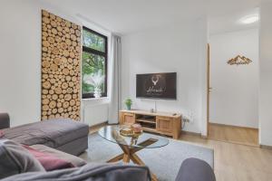 a living room with a couch and a table at HIRSCH Stadt Apartment 3 - Balkon mit Flussblick - Parkplatz in Bad Harzburg +21 photos