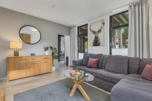 a living room with a couch and a table at HIRSCH Stadt Apartment 3 - Balkon mit Flussblick - Parkplatz in Bad Harzburg