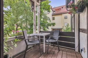 a table and chairs on the balcony of a building at HIRSCH Stadt Apartment 3 - Balkon mit Flussblick - Parkplatz in Bad Harzburg