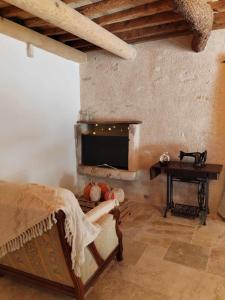 a bedroom with a fireplace and a bed and a table at La Tanière in Lagarde-Paréol