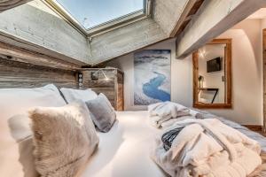 a bedroom with a white bed with a skylight at Résidence Eagle Lodge - En chalet 6 Pièces duplex 4 - 124m2 MAE-3964 in Tignes