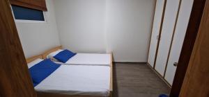 a small room with two beds and a door at malibu bay resort in Ed Dkârîne