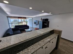 a kitchen with a counter top and a living room at malibu bay resort in Ed Dkârîne