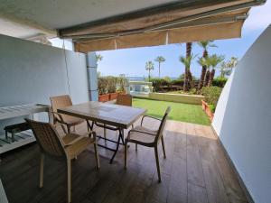 a table and chairs on a patio with a lawn at malibu bay resort in Ed Dkârîne