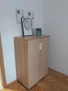 a wooden cabinet in a room with two pictures on it at Apartament, 2 pokoje, stacja metra Kabaty, Ursynów in Warsaw +6 photos