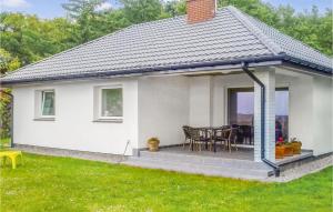 une maison blanche avec une terrasse avec une table dans l'établissement Holiday Home Nowe Warpno Szczecinska, à Karszno 27 autres photos