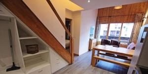 a living room with a dining room table and a staircase at Résidence Grand Tichot B - 4 pièces 80m2 - Au coeur du Val Claret MAE-2314 in Tignes