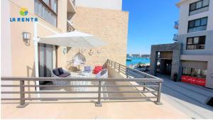un balcon avec un parasol et deux chaises et un parasol dans l'établissement Marina marassi, à Sīdī ‘Abd ar Raḩmān