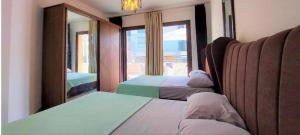 une chambre avec deux lits et une grande fenêtre dans l'établissement Marina marassi, à Sīdī ‘Abd ar Raḩmān