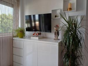 a living room with a tv on a white shelf at Eco friendly apartment in Ližnjan +8 photos