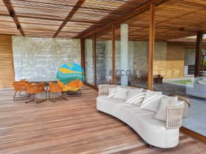 a living room with a white couch on a wooden deck at Villa Ramatuelle, Praia do Forte in Praia do Forte