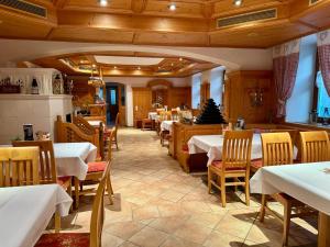 a dining room with tables and chairs in a restaurant at Hotel Ledererwirt in Sankt Lambrecht
