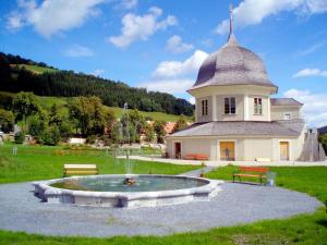 a building with a fountain in the middle of a yard at Hotel Ledererwirt in Sankt Lambrecht